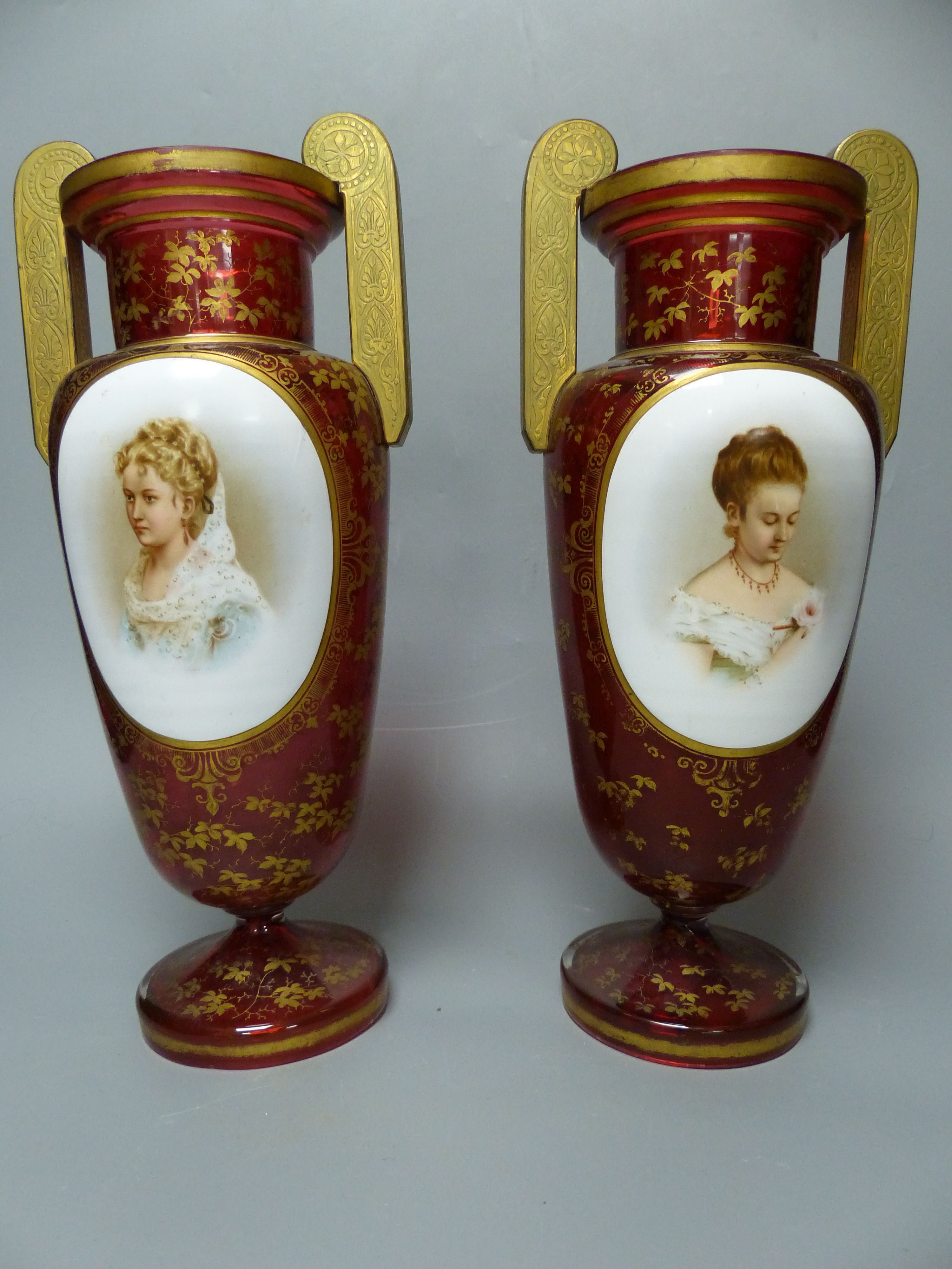 A pair of Bohemian gilt decorated ruby glass two handled vases, late 19th century, height 32cm